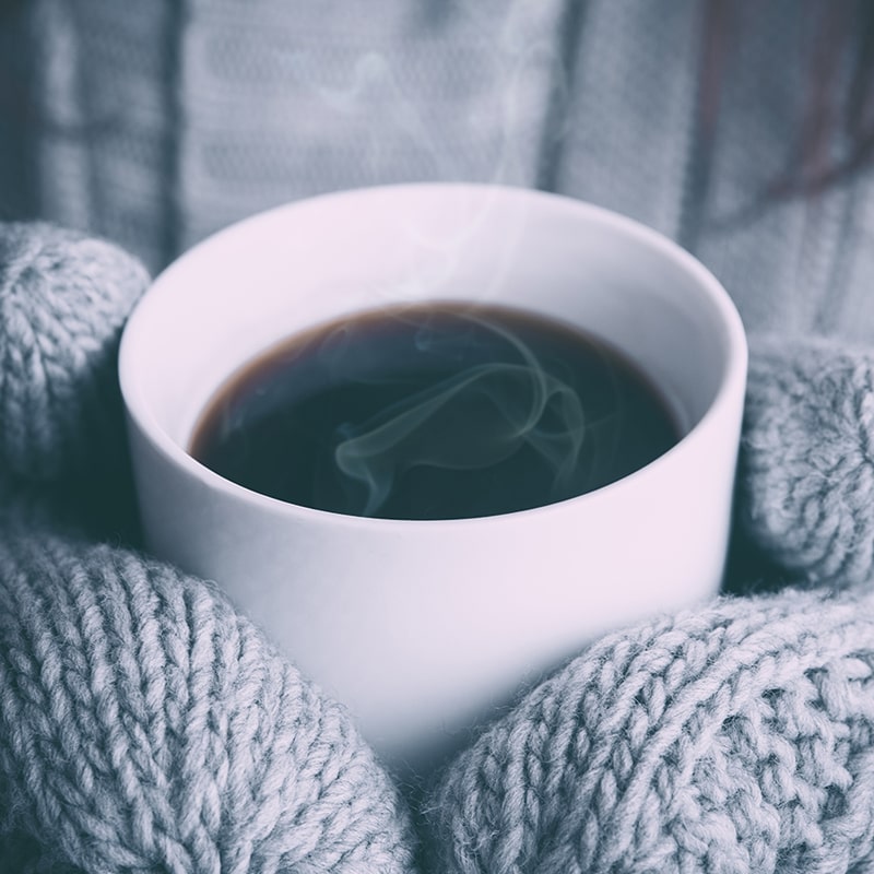 Cosy image of person holding tea